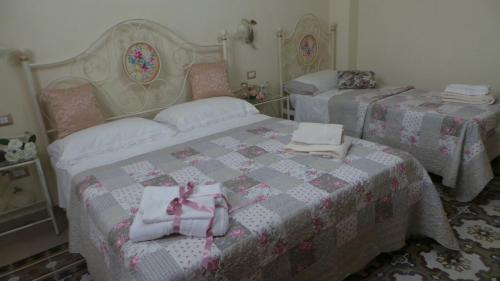 a bedroom with two beds with towels on them at Oasi Ottocento in Quartu SantʼElena