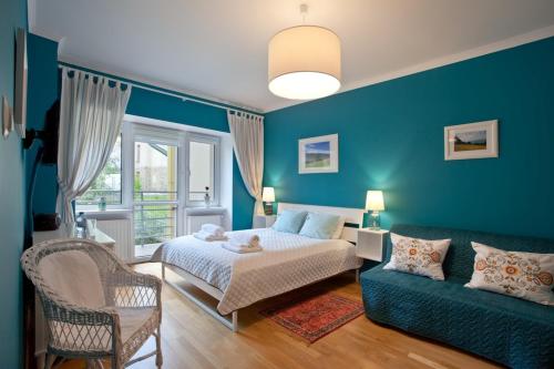 Trzy Siostry في كرينيتسا زدروي: غرفة نوم زرقاء مع سرير وأريكة