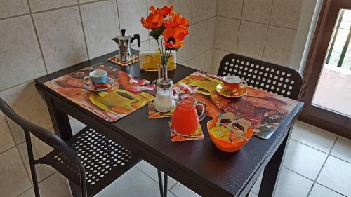 una mesa con comida, bebidas y flores. en B&B Italo House, en Opera