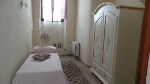 a small bedroom with two beds and a dresser at Oasi Ottocento in Quartu SantʼElena