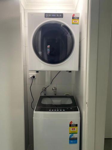 a microwave oven sitting on top of a refrigerator at Urban Beachside Escape near Eastgardens in Sydney