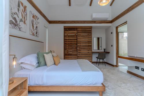 バラクラバにあるJacaranda Luxury Villas by Maritim Villas & Residencesの大きな白いベッドとテーブルのある寝室