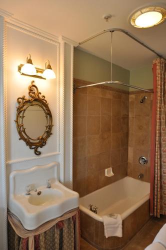 a bathroom with a sink and a tub and a mirror at Bluff View Inn in Chattanooga