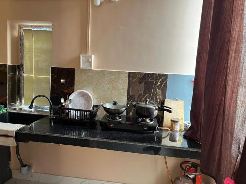 - un comptoir de cuisine avec 2 casseroles et des poêles sur une cuisinière dans l'établissement BKD Casa, à Guwahati