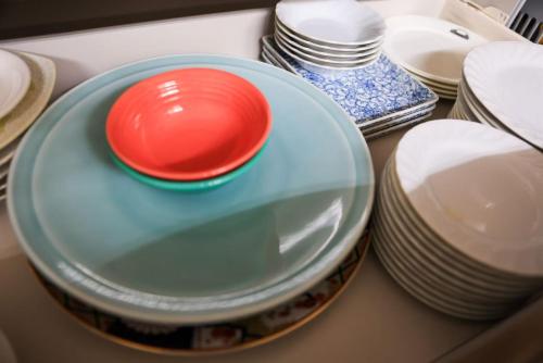 a pile of plates and bowls on a table at ゲストハウスシナノスイー Guest House Shinano Swee in Omachi