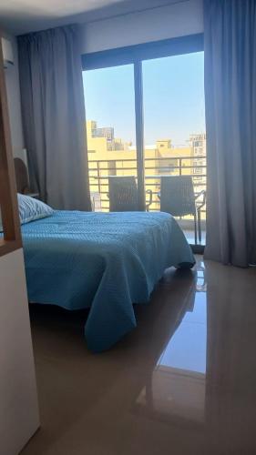 a bedroom with a bed and a large window at Ojo Turco Monoambiente Temporario in Santiago del Estero