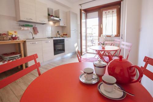 a kitchen with a red table with two cups on it at Carillon in Civitavecchia