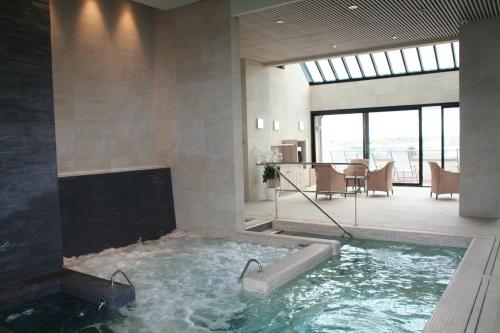 a hot tub in a room with a fireplace at Hôtel Le Nouveau Monde in Saint Malo