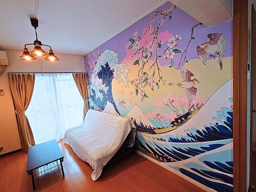 a bedroom with a painting of a wave on the wall at Westeria201 ペット子供歓迎JR春日井駅より徒歩3分長期滞在に最適 in Kasugai