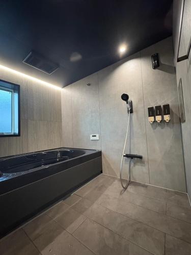 a bathroom with a shower and a bath tub at Tsubame Zushi Hayama in Zushi