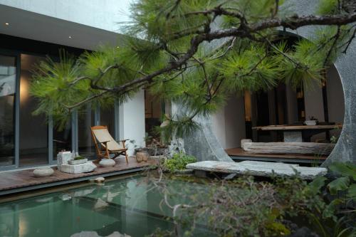 een huis met een zwembad, een stoel en een boom bij 大理古城归渊民宿 in Dali (oude stad)