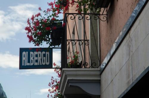a street sign and a balcony with flowers on a building at Stella d'Oro in Lamon