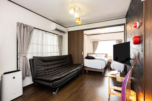 un salon avec un canapé en cuir et une chambre dans l'établissement Vacation Rental NISHIDA, à Kagoshima