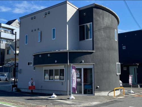 a building with a man standing in front of it at 簡易宿所　ふくろく in Shingu