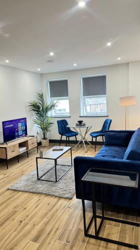 a living room with a blue couch and chairs at Luxury Apartment Close to Elstree & Borehamwood Station in Borehamwood