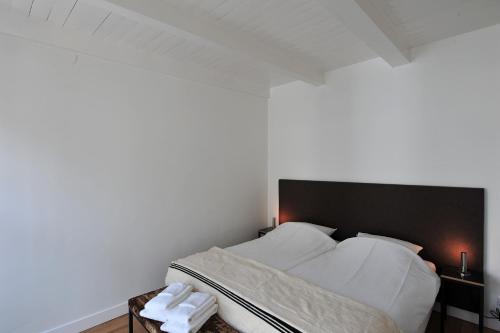 a bedroom with a bed with white sheets and pillows at Boetiek Hotel Kampen in Kampen