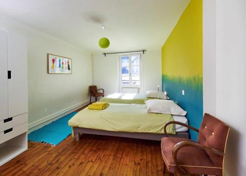 a bedroom with a bed and a chair in it at Chez Nolwenn in Quimper