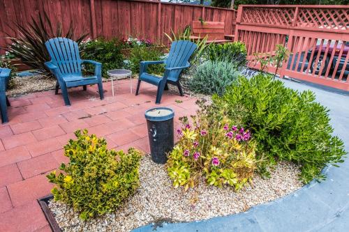 two blue chairs and flowers in a garden at Pelican Inn in Monterey