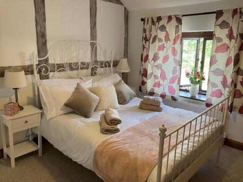 a bedroom with a white bed and a window at Character Cottage in Usk in Usk