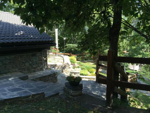 a wooden fence next to a house with a tree at CHALET A CERESOLE REALE nel Parco Gran Paradiso in Ceresole Reale