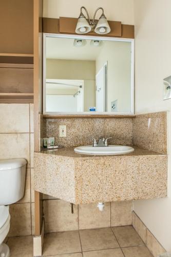 a bathroom with a sink and a mirror at Pelican Inn in Monterey