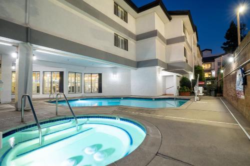 a swimming pool with a bath tub in front of a building at Governors Inn Hotel in Sacramento
