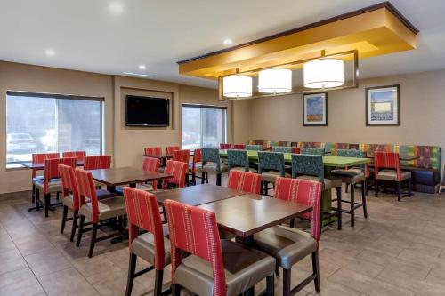 Un restaurante con mesas y sillas y un televisor de pantalla plana. en Comfort Inn & Suites North Dallas-Addison, en Dallas