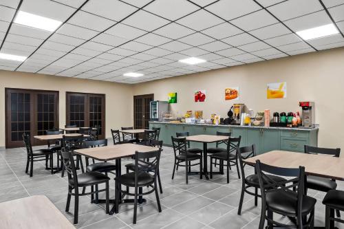 ein Esszimmer mit Tischen, Stühlen und einer Theke in der Unterkunft Quality Inn Harvey - New Orleans in Harvey