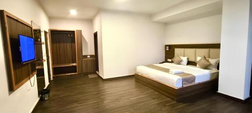a bedroom with a bed and a flat screen tv at VITS Kunjham Retreat in Gangtok