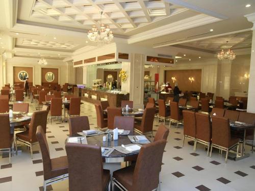 a dining room with tables and chairs in a restaurant at Inzone Garland Hotel Taian in Tai'an