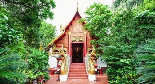 a nepalese temple with stairs leading to the door at Sofia Hostel in Chiang Rai