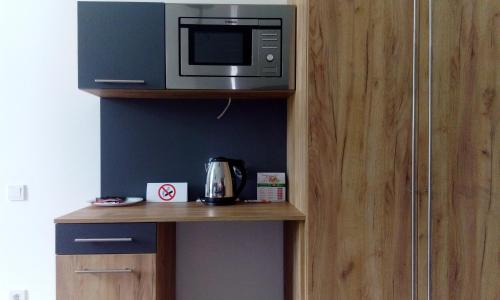 a microwave sitting on top of a wooden shelf at Partner Guest House Khreschatyk in Kyiv