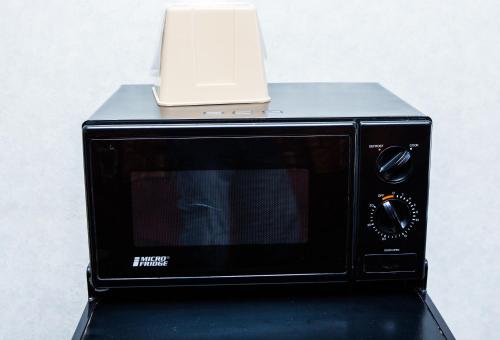a microwave with a laptop on top of it at Pelican Inn in Monterey