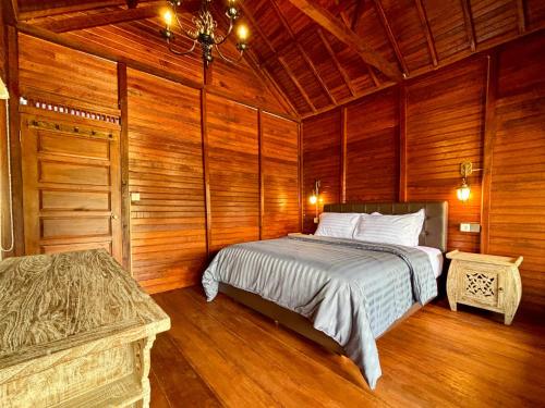 una camera da letto con un letto in una stanza di legno di Shankara Forest Haven Villa by AGATA a Jatiluwih