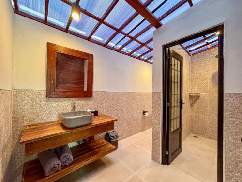 bagno con lavandino e soffitto in vetro di Shankara Forest Haven Villa by AGATA a Jatiluwih