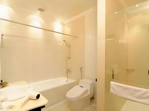 e bagno bianco con servizi igienici e vasca. di Yusro Hotel Restaurant & Convention a Jombang