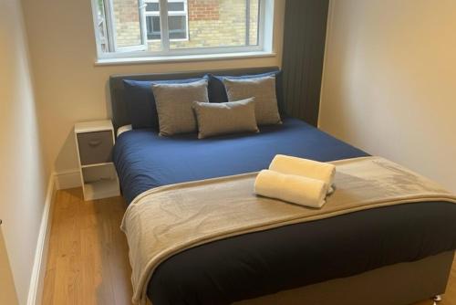 ボアハムウッドにあるCosy 4 bedroom in borehamwoodのベッドルーム1室(青いベッド1台、窓付)