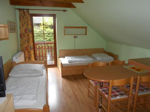 ジェレズナー・ルダにあるApartmány Base Campのベッド2台、テーブル、椅子が備わる客室です。
