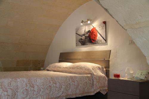 ルッファーノにあるCasa Cadornaのベッドルーム1室(壁に赤いマスク付きのベッド1台付)