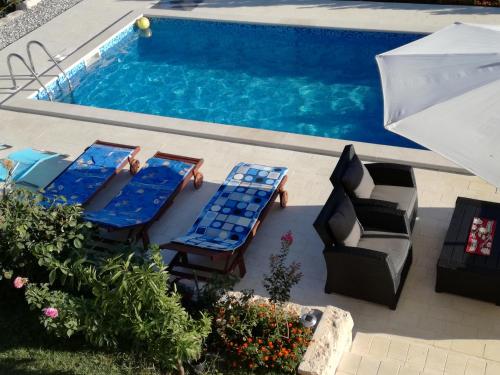 an overhead view of a swimming pool with lounge chairs and an umbrella at Apartments Jankovic in Vodice