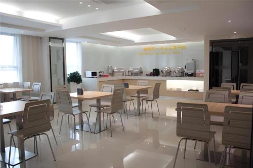 a restaurant with tables and chairs and a kitchen at City Comfort Inn Foshan Shunde Daliang Qinghui Garden Xinsong in Shunde