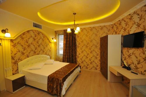 um quarto com uma cama com um tecto amarelo em Hotel Iberia em Batumi