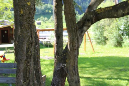 a park with a playground and trees with a bench at Appartement Ackerli in Pettneu am Arlberg