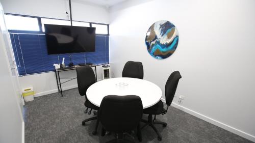 a meeting room with a white table and black chairs at Port Lincoln Villas in Port Lincoln