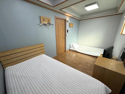 慶州市にあるGyeongju Bee Houseのベッド2台付きの部屋とドア付きの部屋