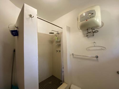 Un baño blanco con ducha y WC. en Beautiful traditional style studio, en Maputo