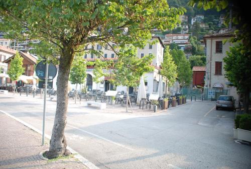 a tree on a street with tables and chairs at Lakeside Studio in Como