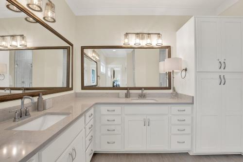 a white bathroom with two sinks and a large mirror at Blue Heaven Villa in Tybee Island