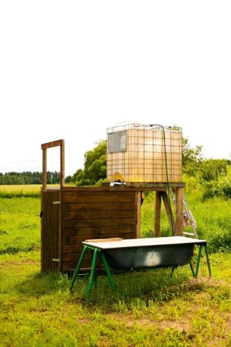 a bath tub sitting in the grass in a field at Kakulaane Tourism Farm in Lauküla