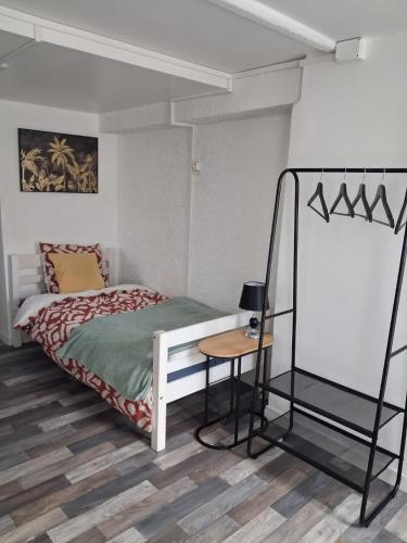 a bedroom with a bed and a table in it at location dreux in Dreux